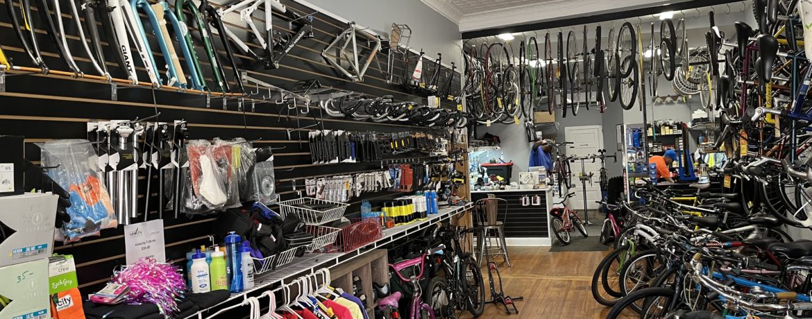 Interior view of bike shop with two mechanics working on bikes